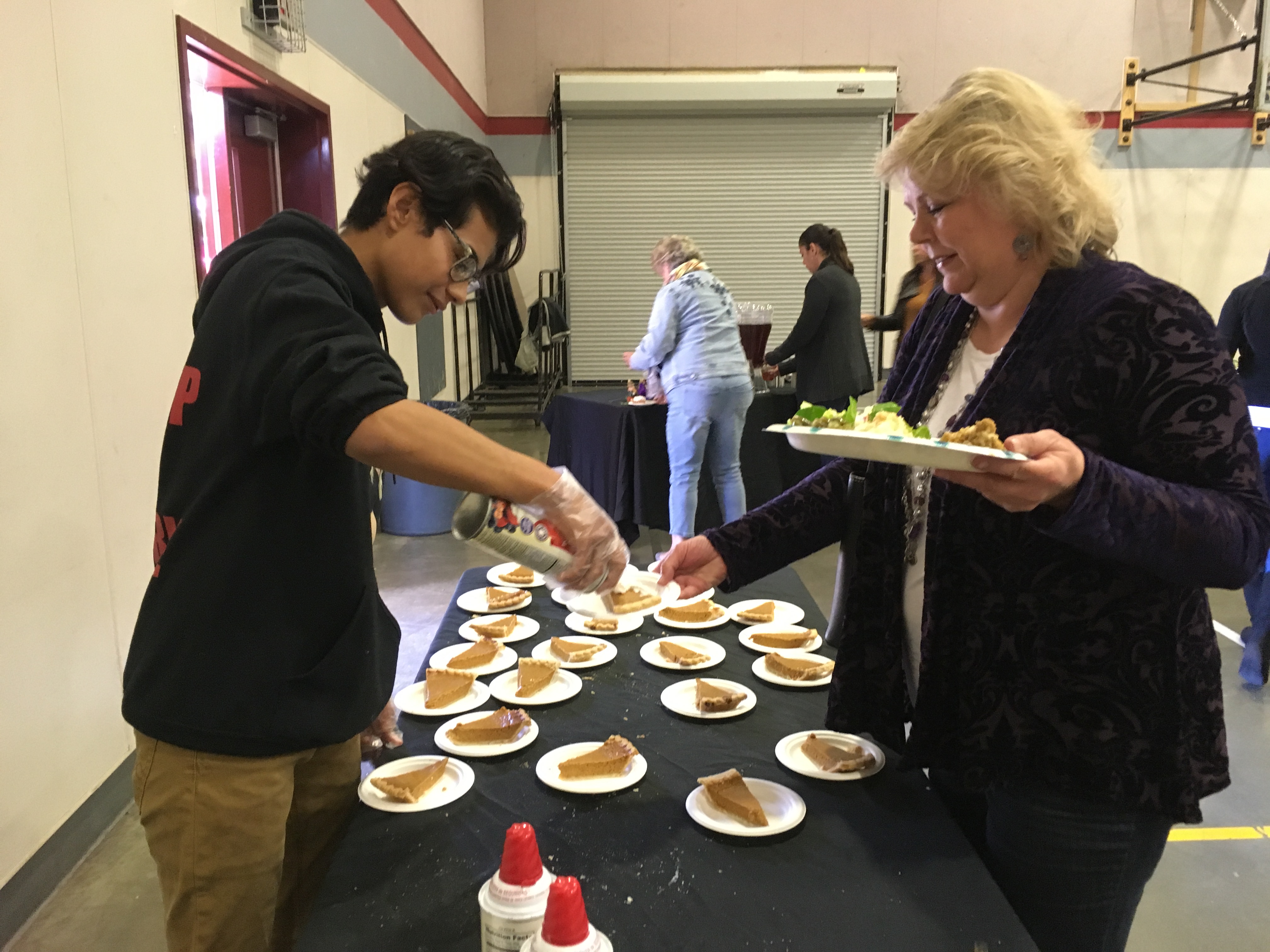 Tenth-grade student, Bryan Jimenez sweetens pumpkin pie with a little whipped cream