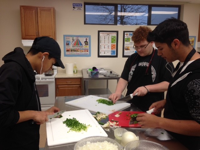 Bryan Jimenez, Elias Brown, Alexander Camancho practice mincing in Culinary Arts class.